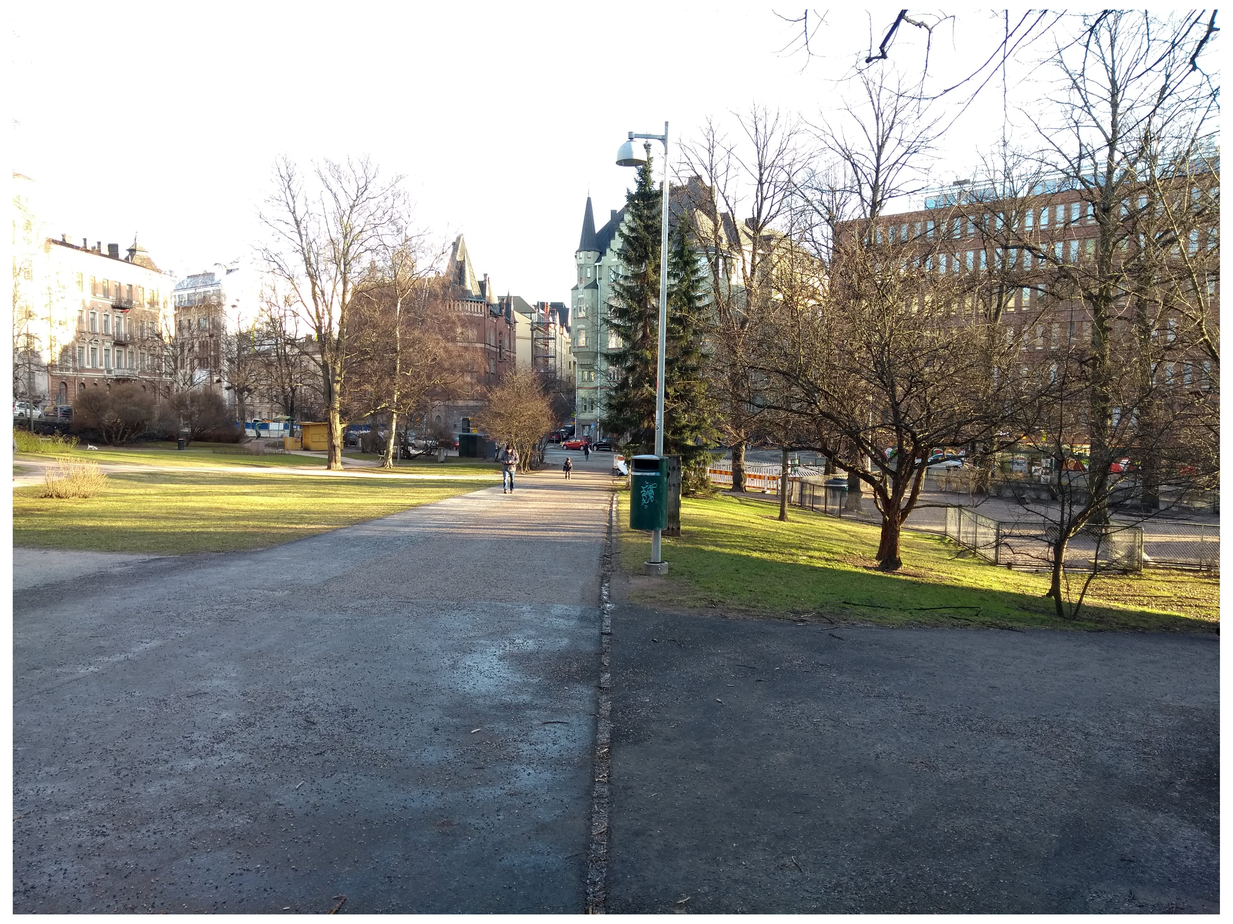 Katajanokka. Näkymä Kanavakadulta itään Satamakadun suuntaan, nykyisin paikalla on Tove Janssonin puiston puistokäytävä. Vasemmalla luminen Katajanokan puisto. Taustalla keskellä Satamakatu 5:n kerrostalo Luotsikadun ja Kruunuvuorenkadun kulmassa. rephoto