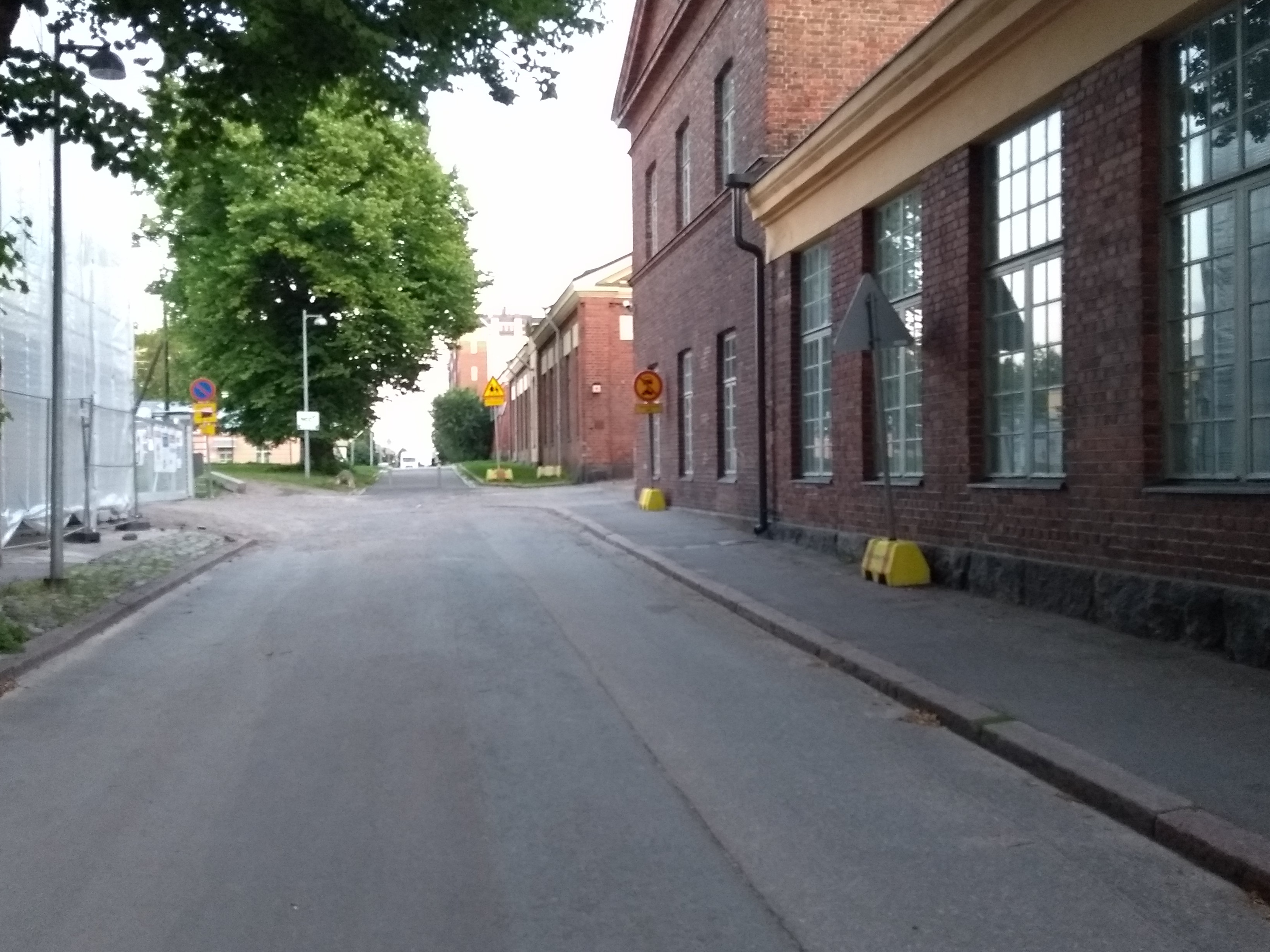 Laivastokuja. Vironniemen päiväkodin lapsia ja aikuisia kävelemässä kevättalven auringonpaisteessa Laivastokujalla veden tippuessa räystäiltä. Oikealla Laivastokuja 6:rakennus. Näkymä kaakkoon Merikasarminkadun suuntaan. Tutustuminen Katajanokan vanhoihin ja uusiin rakennuksiin liittyi päiväkodissa kevätkaudella toteutettuun Viihtyisä ympäristö -projektiin. rephoto
