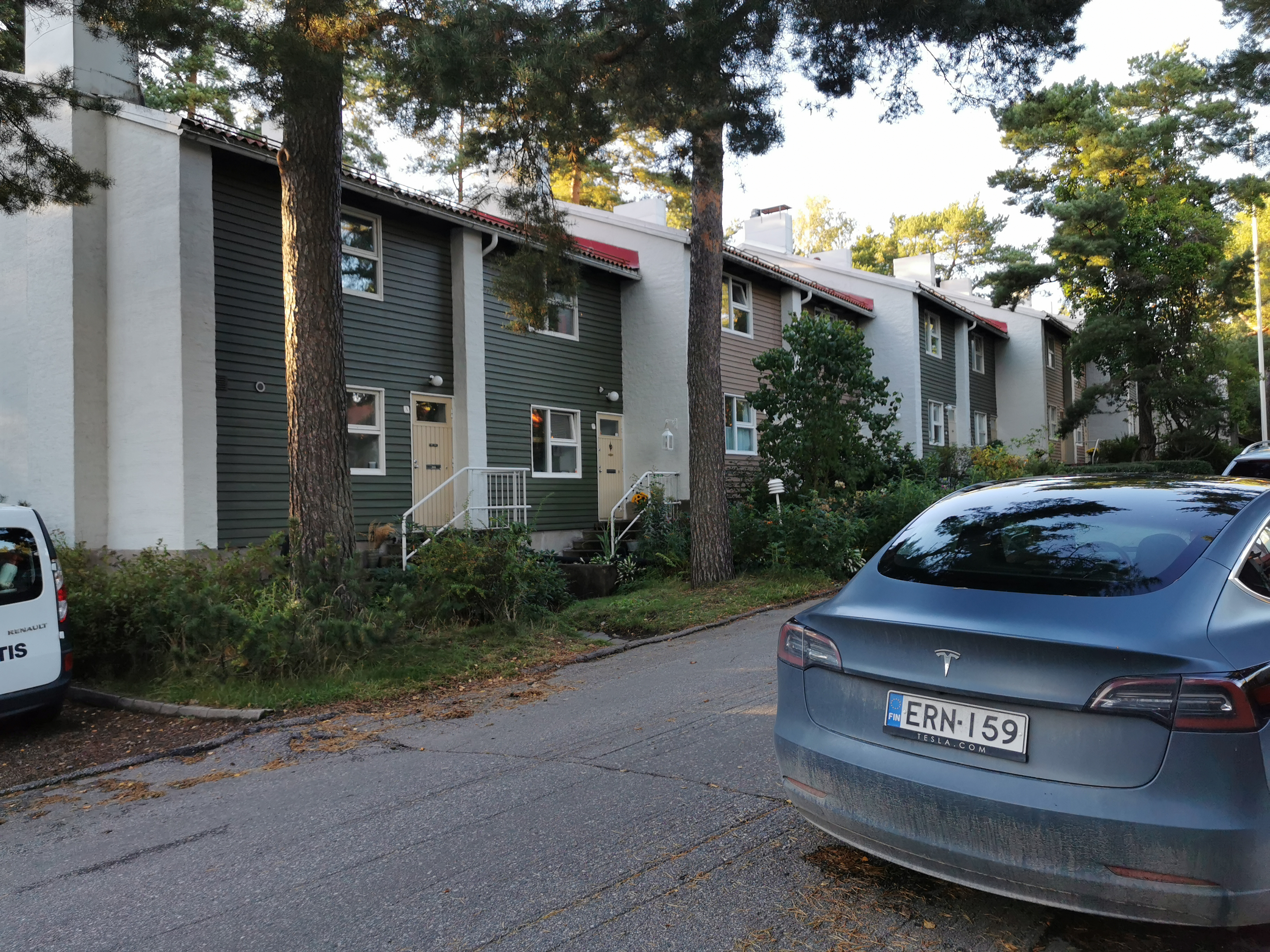 Länsi-Herttoniemi, Karhutie 26. Rivitalo. Kaksi lasta kävelee käsikädessä kuvan reunassa. Rivitalon edessä ulkona kaksi lastenvaunua. rephoto