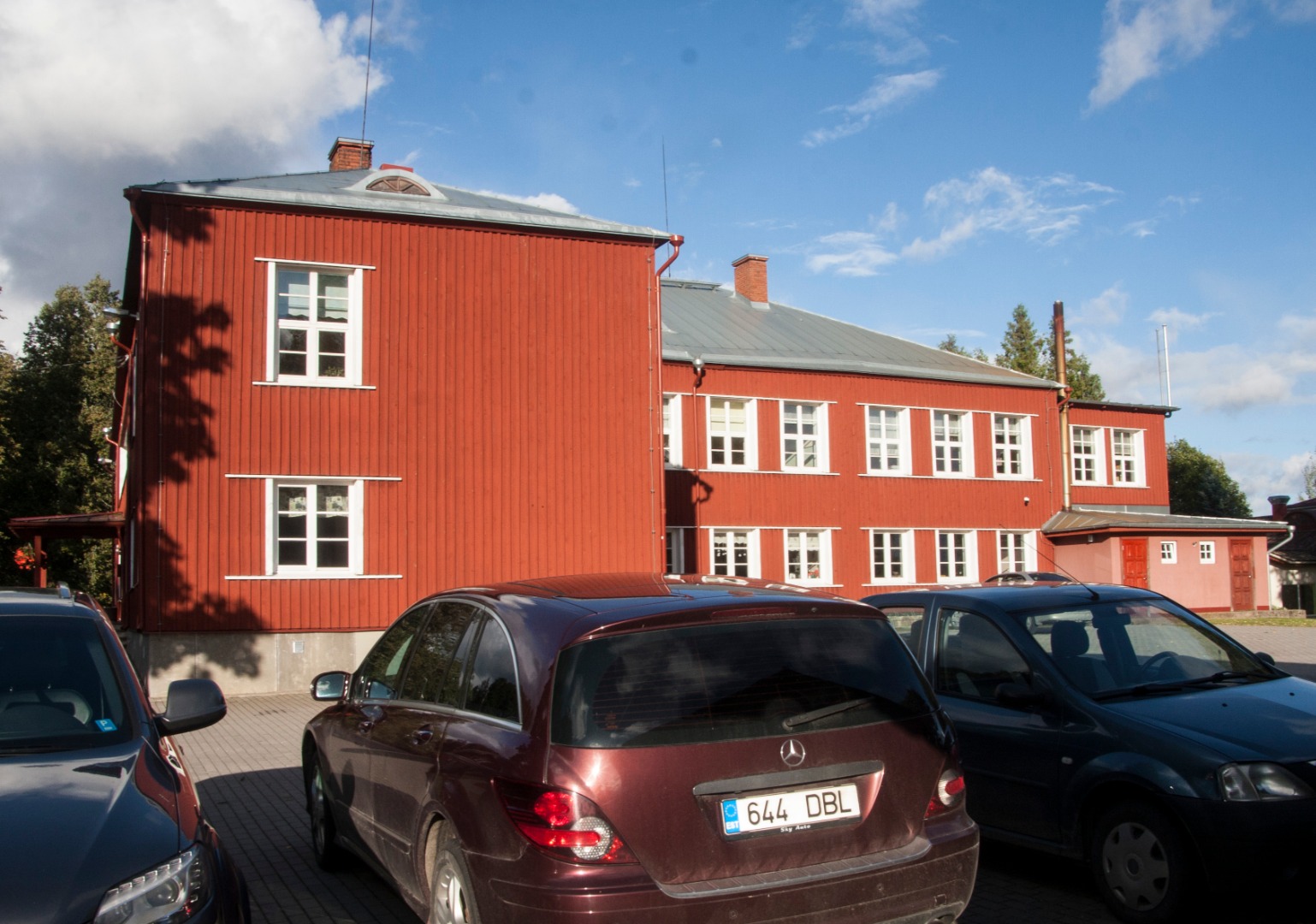 Kahekorruseline puidust koolimaja, vastvalminud. Vaade hoone külgfassaadile, õuel ehitusmaterjalid. rephoto