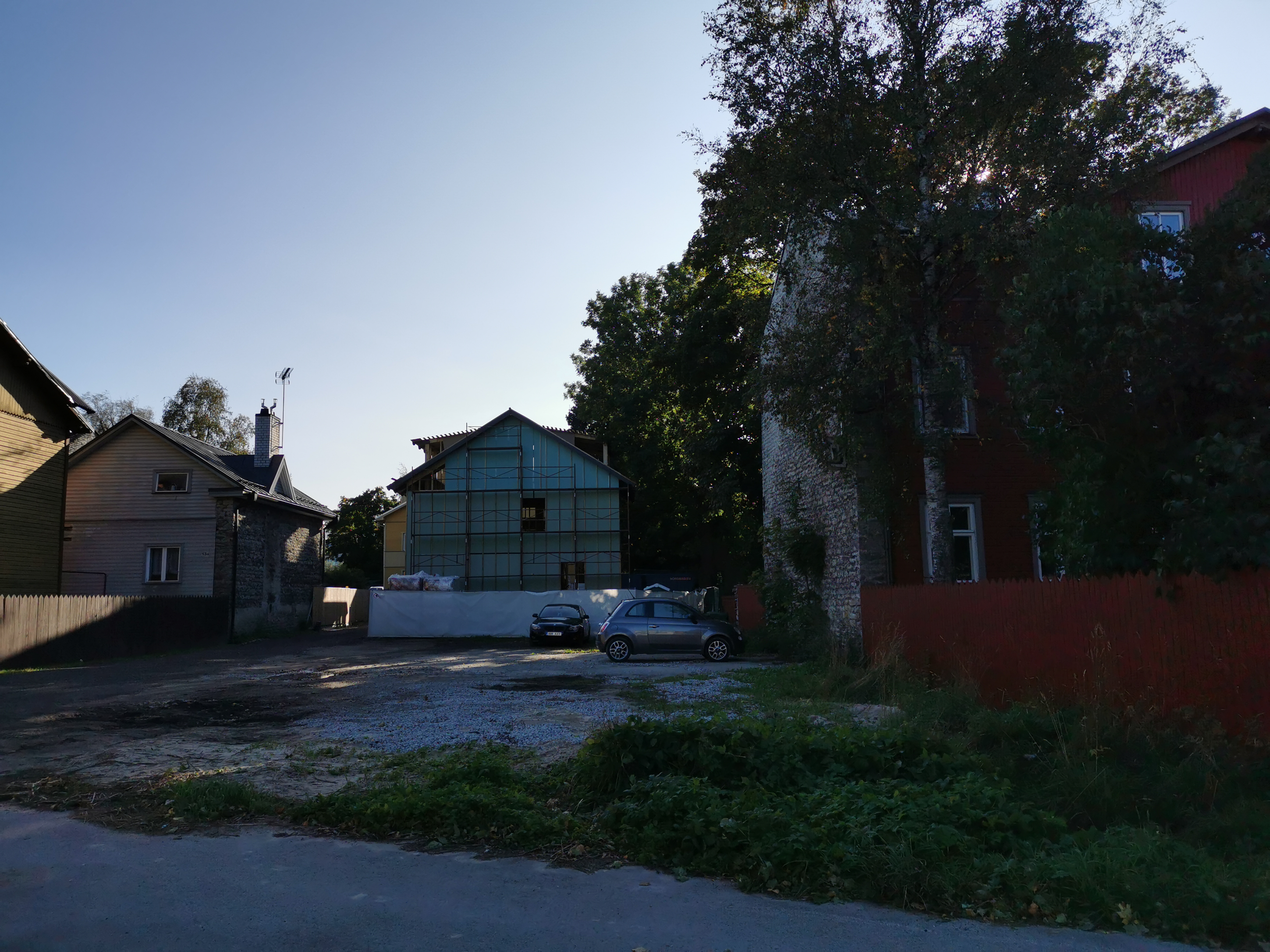 New-Kalamaja Street. Cars and car trucks between the houses on the parking lot. rephoto