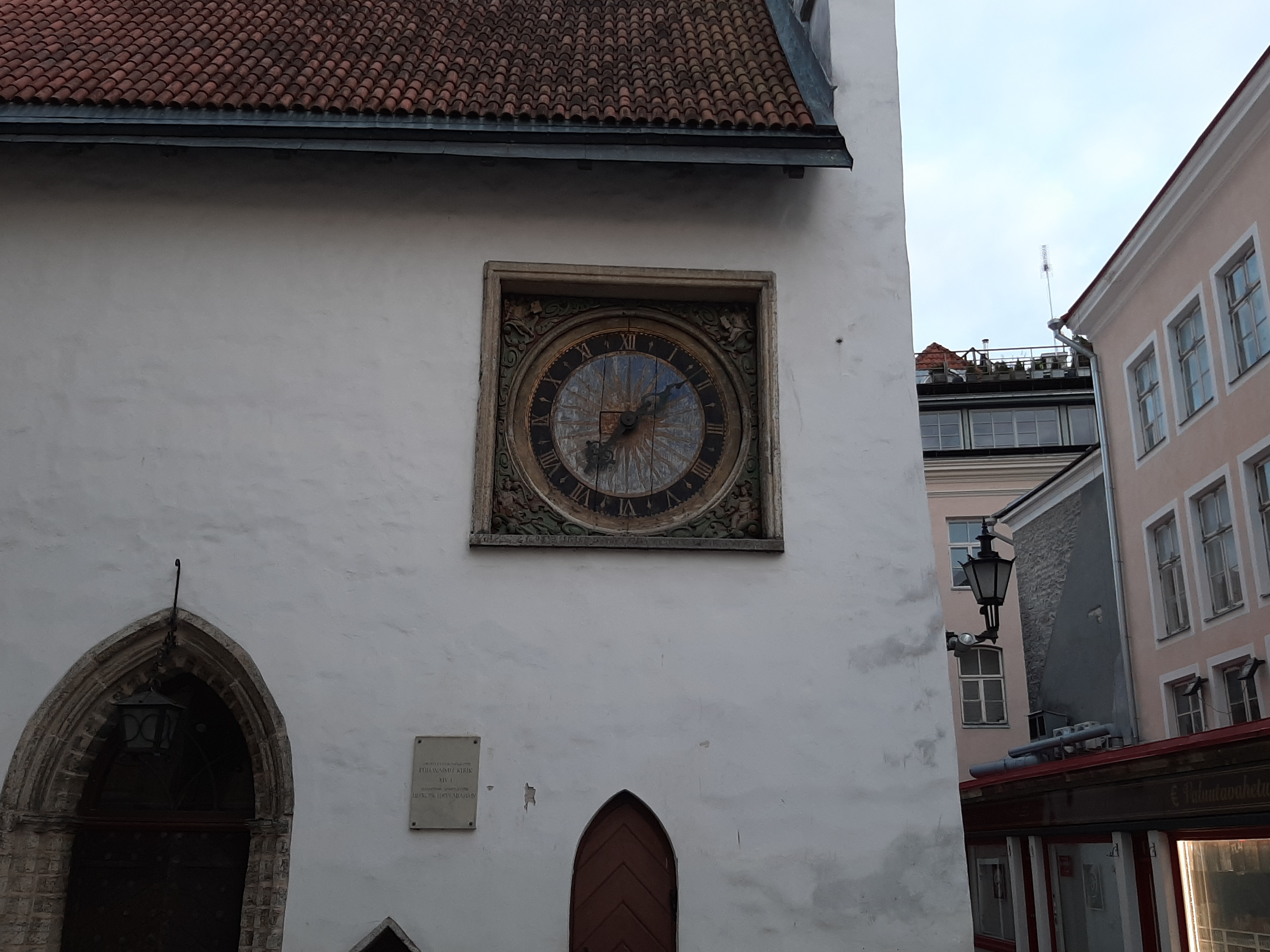 Tallinn, the corner of the Church of the Holy Spirit with restored clock. rephoto