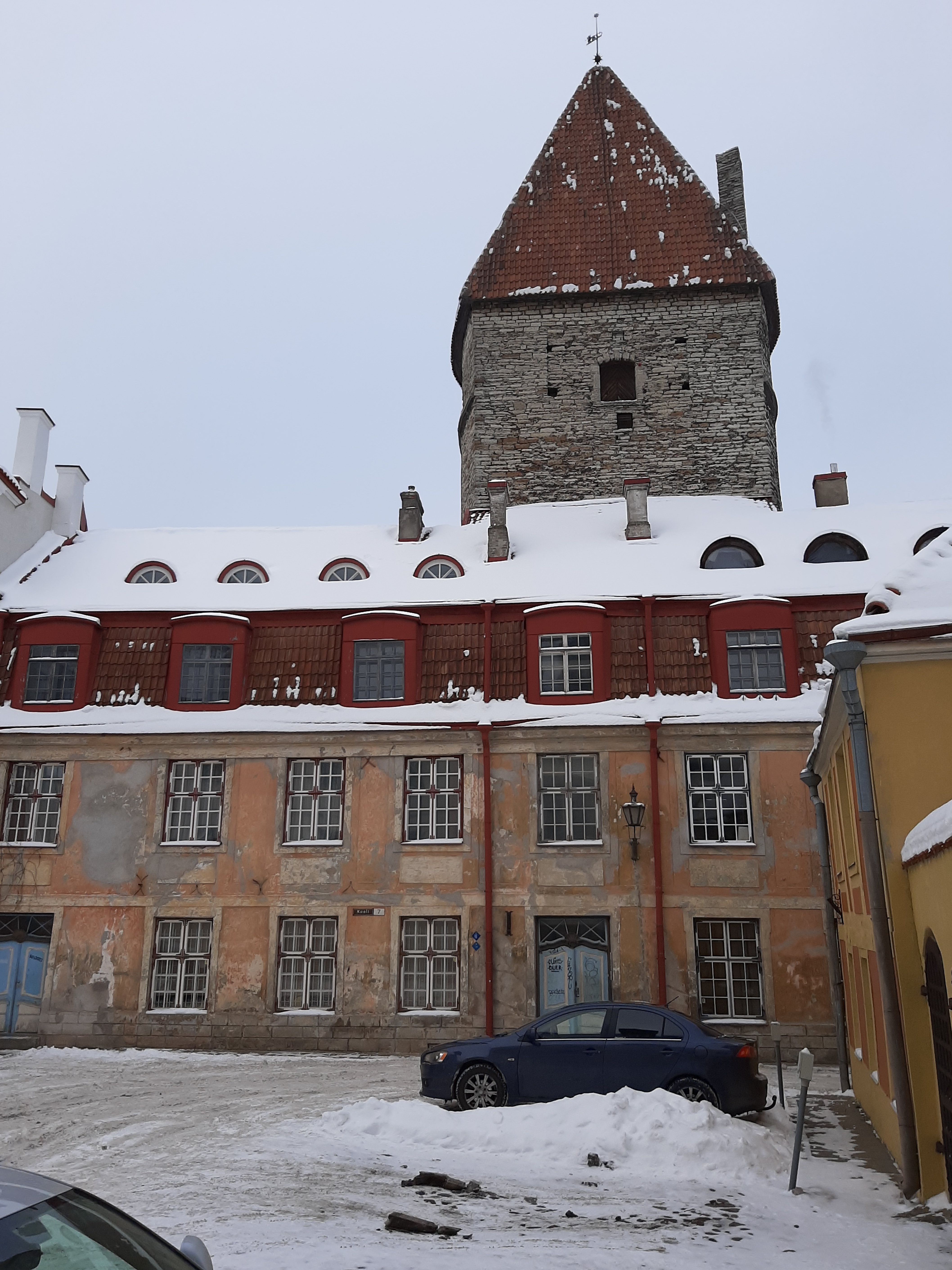 Linnamüüriga külgnev elamu Tallinnas, hoone vaade piki tänavat; vastasmaja katuselt rephoto