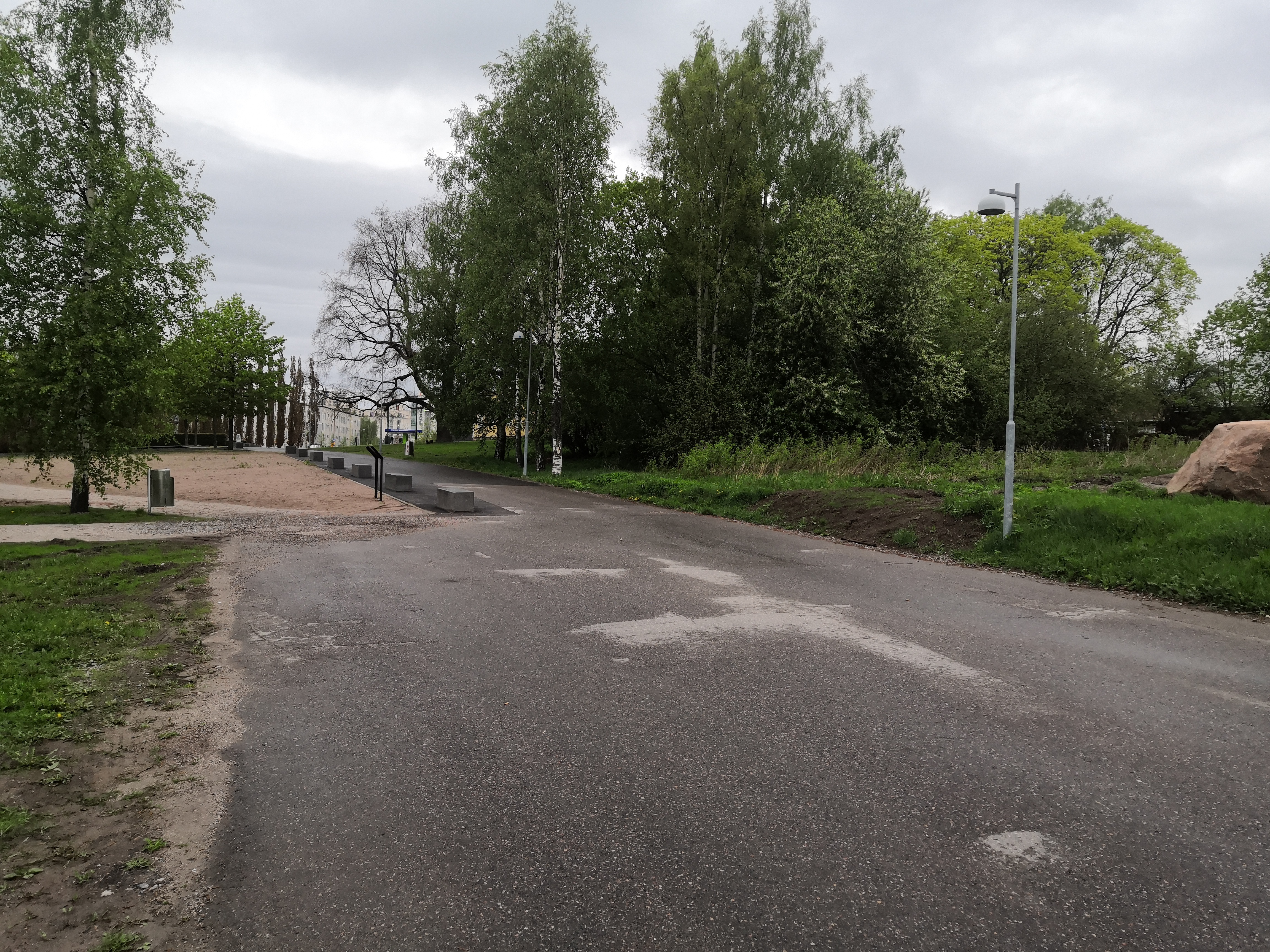 Viikintie. Viikintietä länteen. Taustalla tienviitat vasemmalle Keskustaan, oikealle Lahteen ja Malmille. Vasemmalla Viikin Unionin huoltoasema. Puiden katveessa puurakenteinen kartanorakennus, nykyinen Viikinkaari 8. rephoto