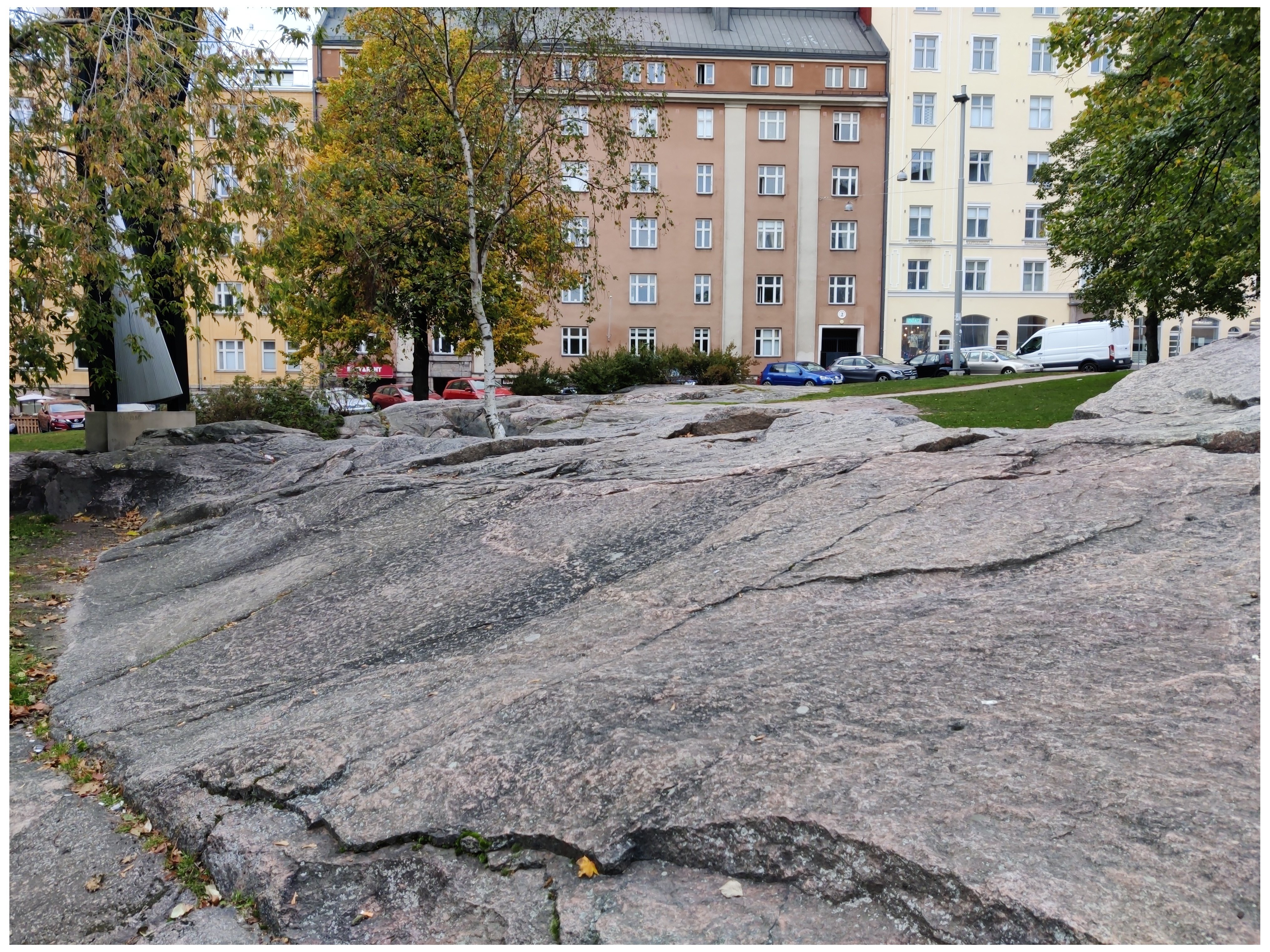 Oppilaita luokkakuvassa kallioilla Porthaninkadun varrella (nyk. Matti Heleniuksen puisto), taustalla Agricolankatu 9 ja 7 sekä halkopinoja. rephoto