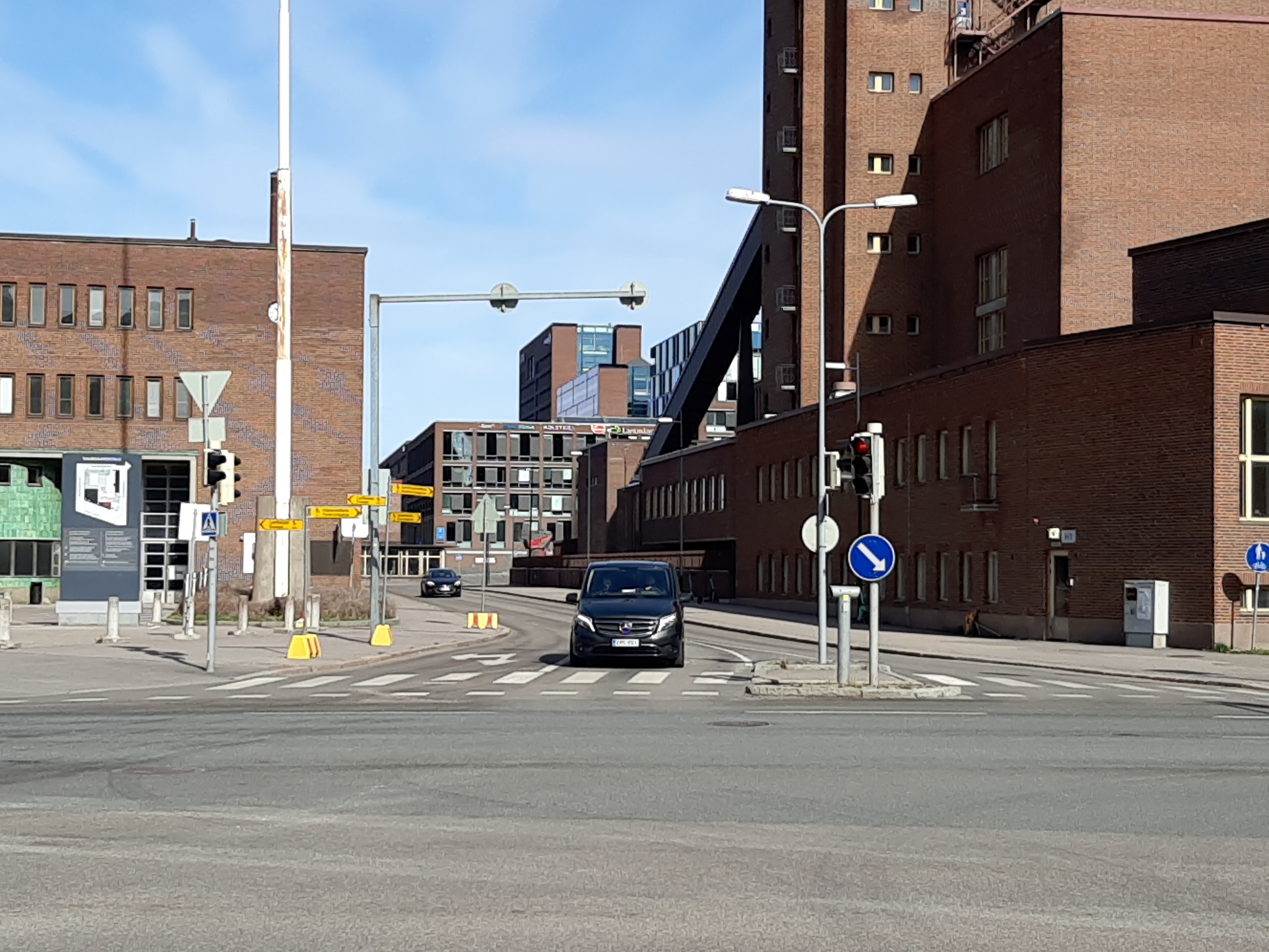 Vasemmalla Oy Alkoholiliike Ab:n (nyk. Oy Alko Ab) tehdas (nyk. Helsingin oikeustalo, Salmisaarentalo), Itämerenkatu 51 (nyk. Porkkalankatu 13). Oikealla Helsingin kaupungin sähkölaitoksen (nyk. Helsingin Energia) Salmisaaren voimala, Lauttasaarenkatu 11 (=Porkkalankatu 11). Keskellä Tallberginkatu. rephoto