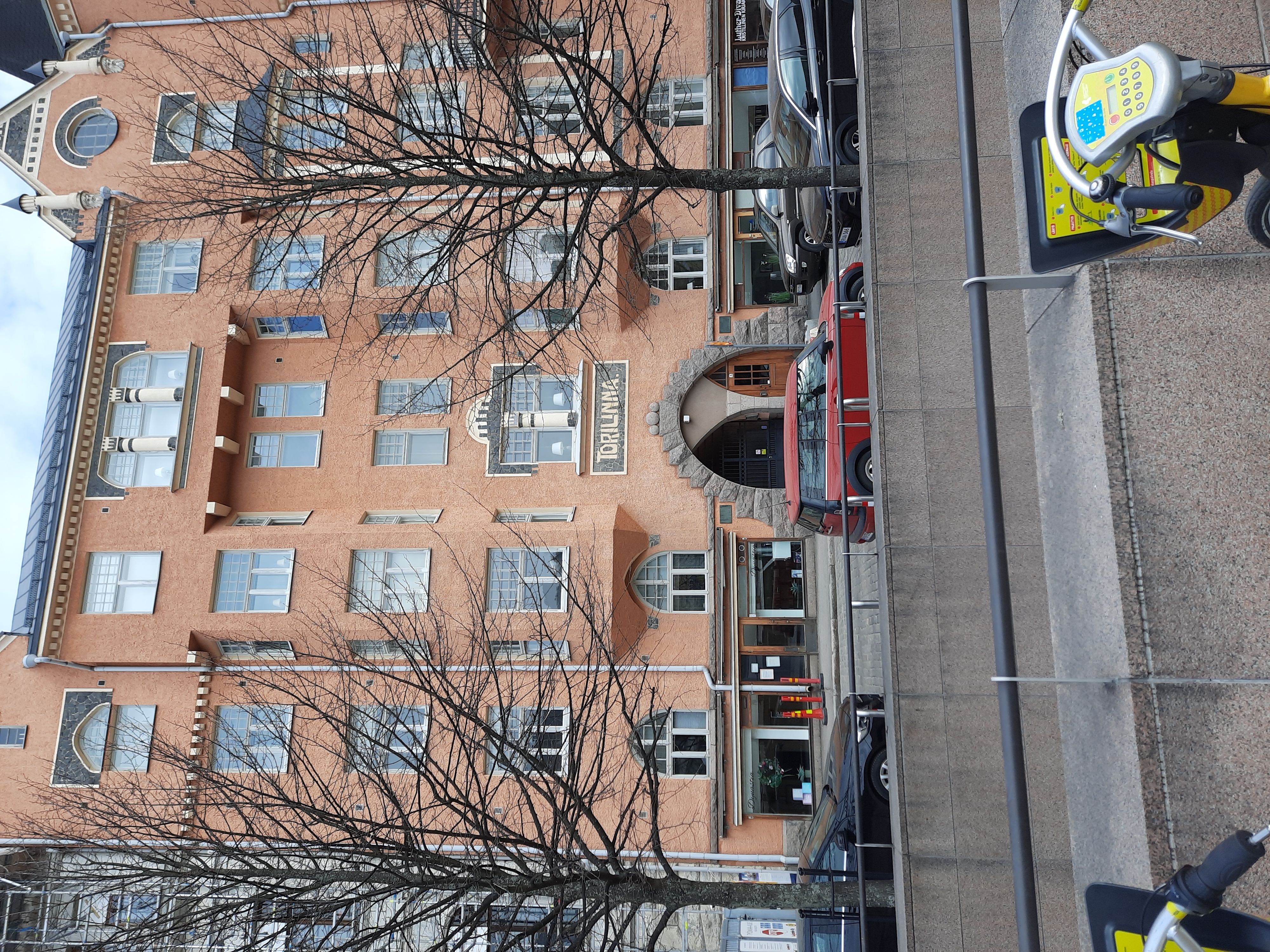 Fabianinkatu 13. Ihmisiä kävelemässä sateisella Fabianinkadulla jugendtalo Torilinnan sisäänkäynnin ja porttikäytävän edustalla Kasarmitorin laidalla. rephoto