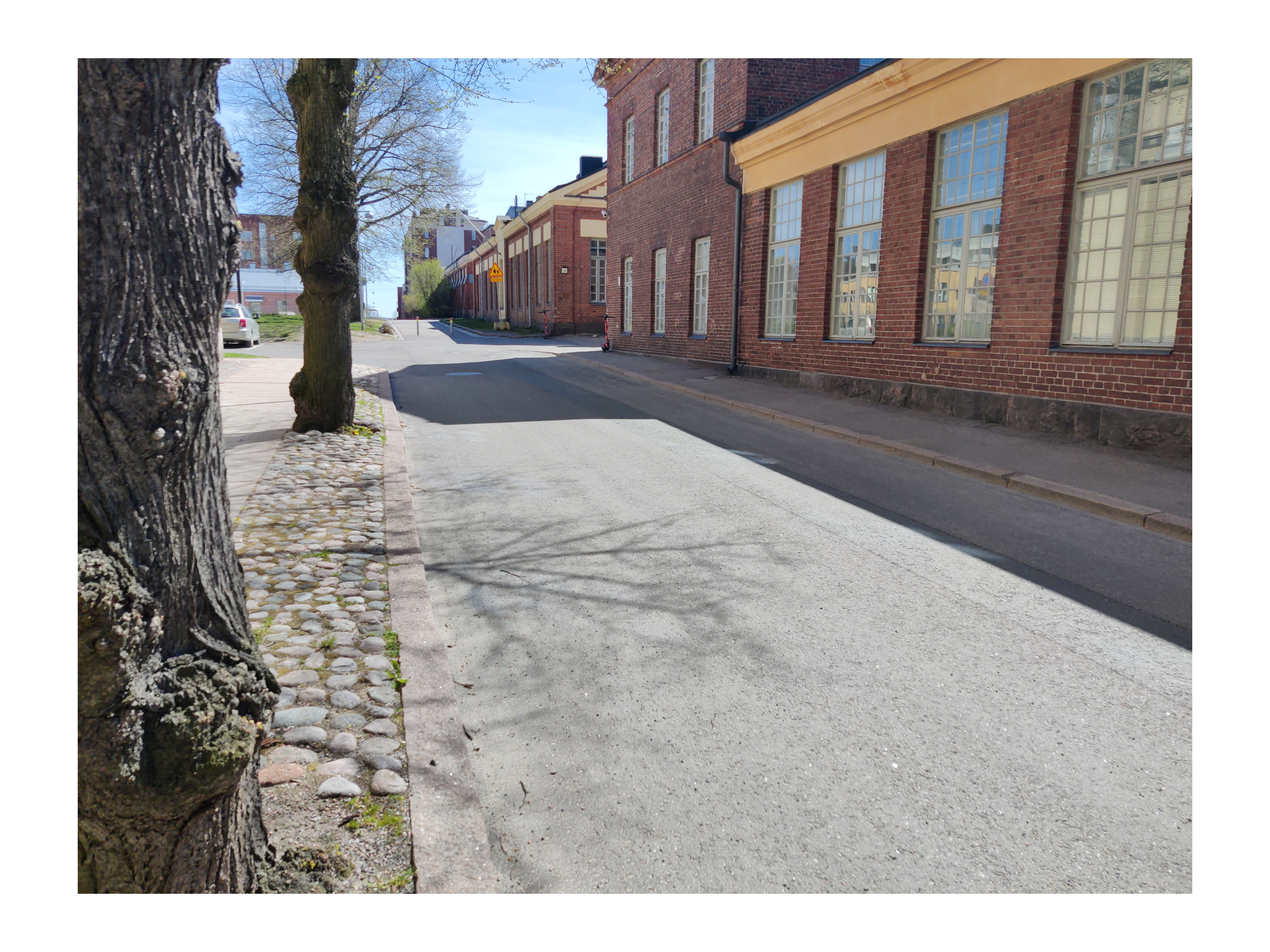 Laivastokuja. Vironniemen päiväkodin lapsia ja aikuisia kävelemässä kevättalven auringonpaisteessa Laivastokujalla veden tippuessa räystäiltä. Oikealla Laivastokuja 6:rakennus. Näkymä kaakkoon Merikasarminkadun suuntaan. Tutustuminen Katajanokan vanhoihin ja uusiin rakennuksiin liittyi päiväkodissa kevätkaudella toteutettuun Viihtyisä ympäristö -projektiin. rephoto