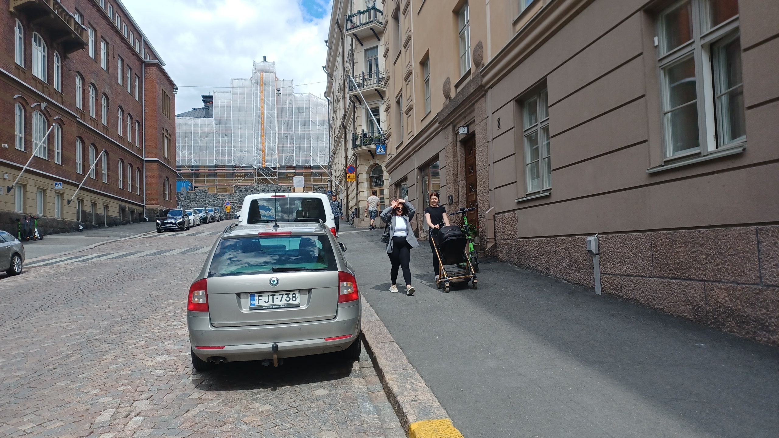 Kruununhaka, Snellmaninkatu. Jonossa kulkevia lapsia sekä lastenvaunuja työntävä nainen kävelemässä ylös lumikinoksen kaventamaa Snellmaninkatua Liisankadun kulmasta Oikokadulle päin. Oikealla Elannon myymälä ja taaempana lihakaupan kyltti. rephoto