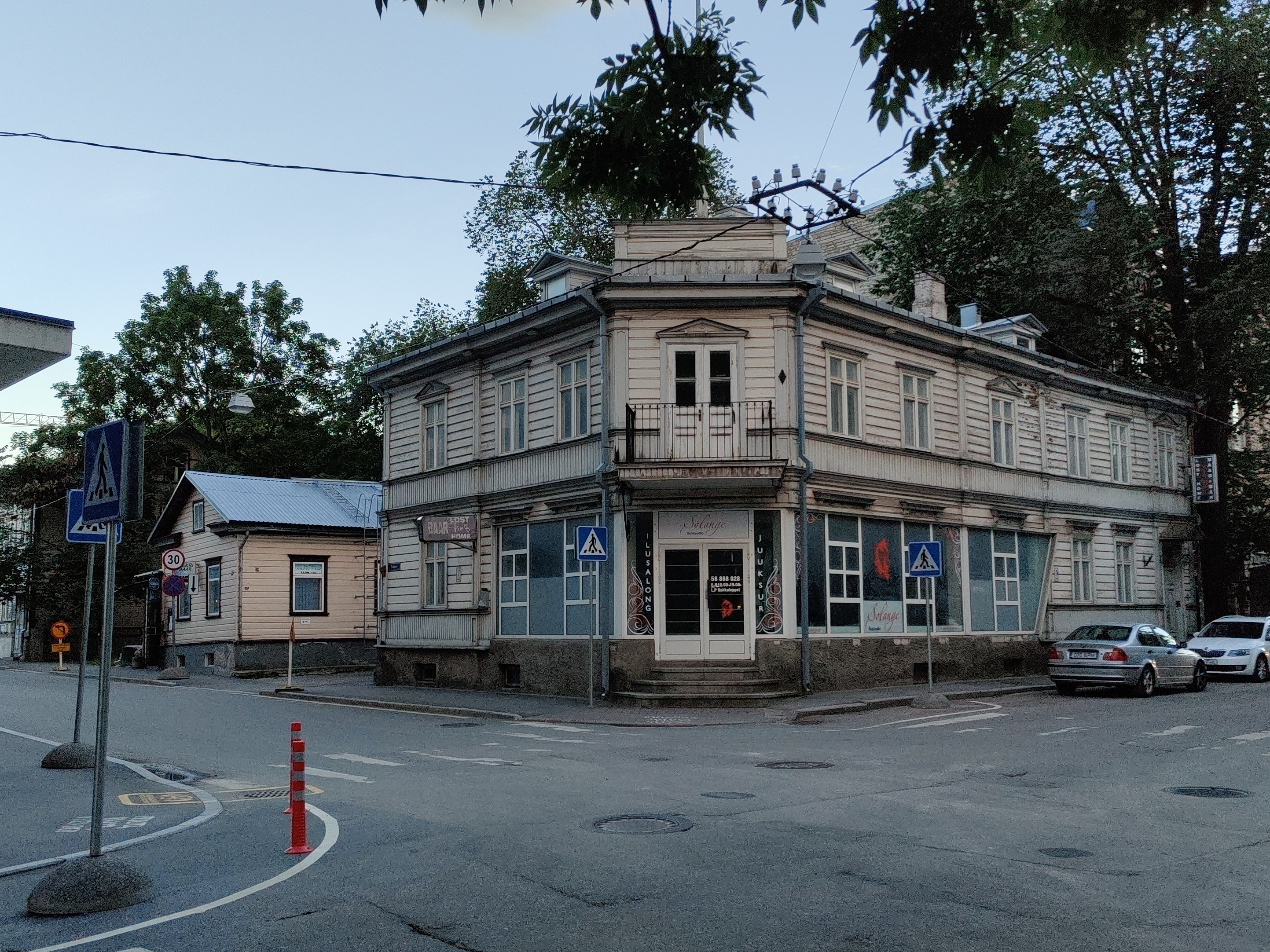 Sakala tn 19 puidust hoone, esiplaanil mantli ja karvamütsiga härra rephoto