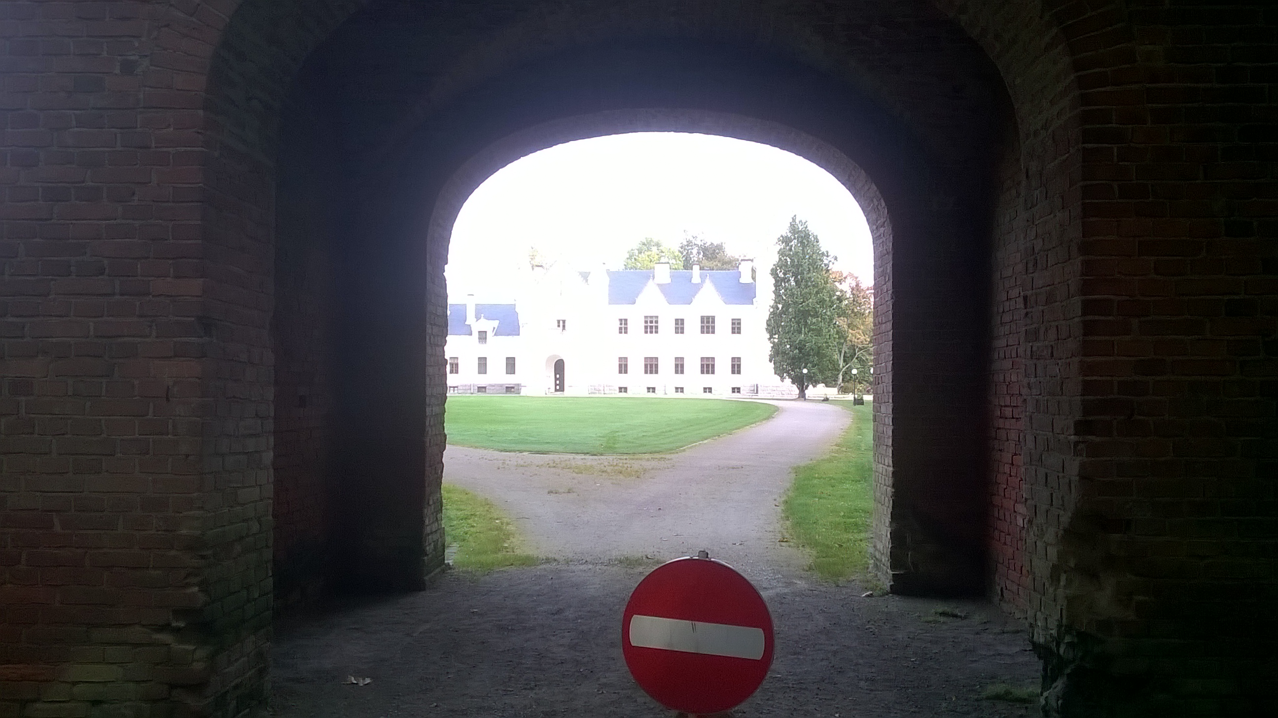 Alatskivi Manor Gate and Manor Building. In front of the brickstone wall and gate. See the main building behind the gate opening. rephoto