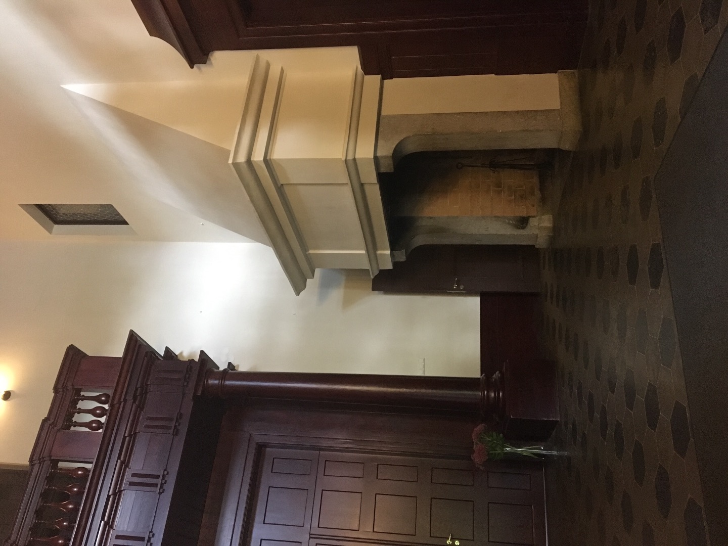 Alatskivi. The hall of the manor. On the left the dark door leads to indoors. On the right high white fireplace; on the white wall crocheted portraits of the manor owner's ancestors. rephoto