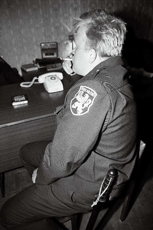 Õismäe politseijaoskonnas Politsei tõmbab suitsu telefoni juures.