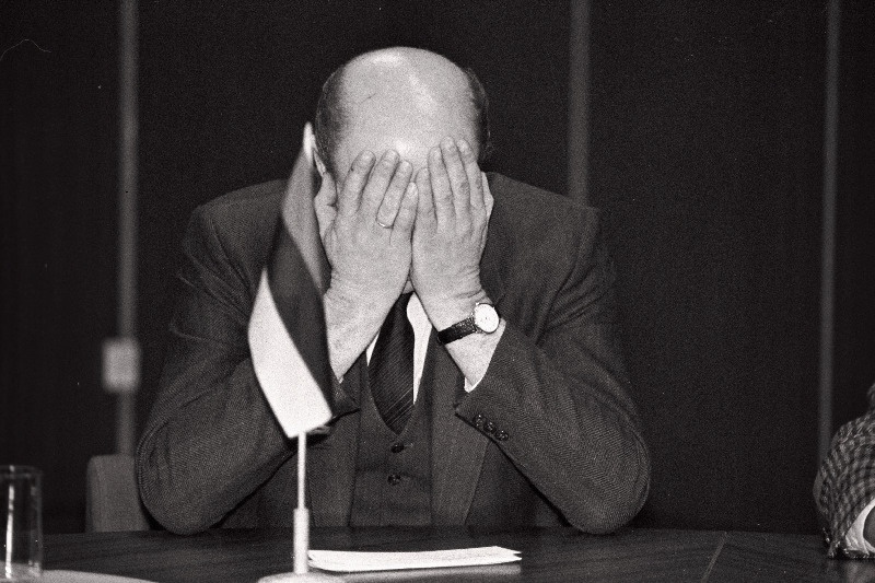 Ain Kalmaru käed näo ees laua taga.