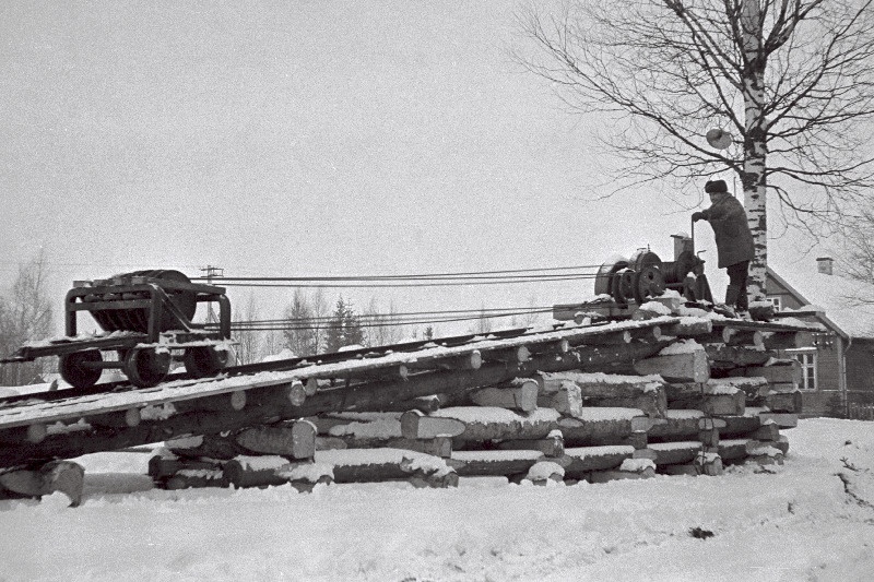 Pärnu rajooni Massiaru metsatööjaoskonna töötaja N. Aleksejev vintsi abil autokoormat estakaadile tõmbamas.