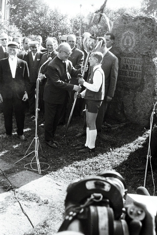 Tartu 2. Keskkooli õpilane Rein Lumiste annab Tartu juubelilaulupeo tõrviku üle Eesti NSV XVII üldlaulupeo üldjuhile Richard Ritsingule.
