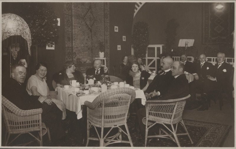 Tartu Suurgildi liikmed koos naistega istumas ja vestlemas