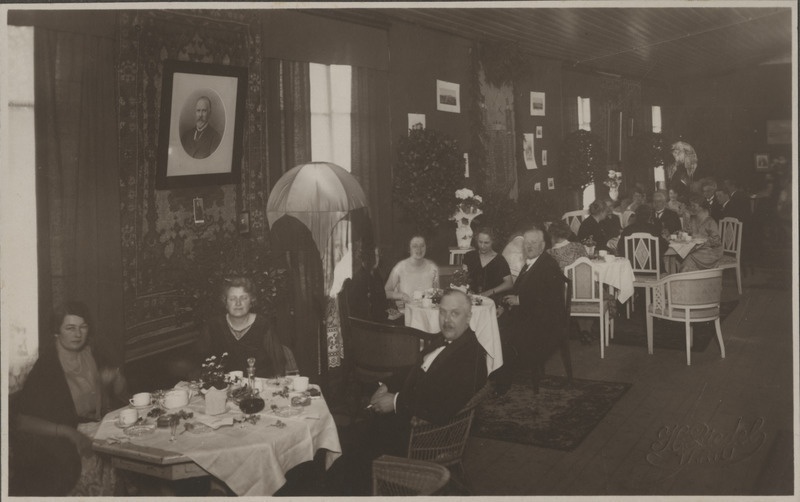 Tartu Suurgildi liikmed koos naistega istumas ja vestlemas