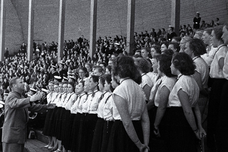Graafik Siima Škopi poolt kujundatud Moskvas toimunud Eesti kunsti- ja kirjandusdekaadi plakat.
Naiskoor dirigent Lembit Verlini juhatusel jaaniõhtul Tallinna Lauluväljakul esinemas.
