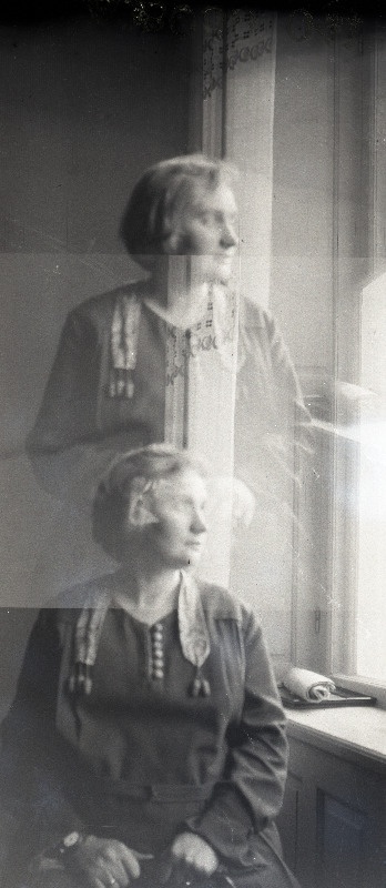 Tundmatu naine akna all istumas