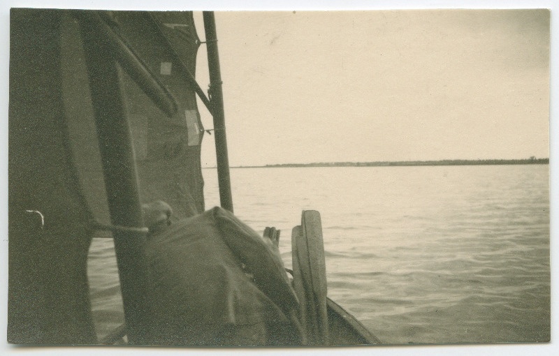 Vaade purjepaadist üle mere rannikule, esiplaanil kummardamas tundmatu mees