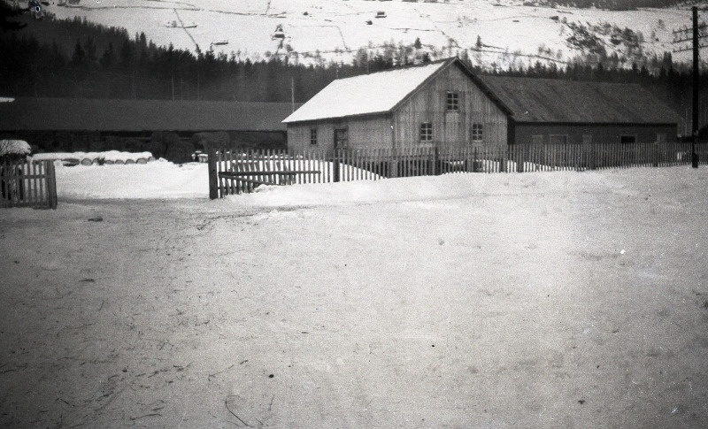 Vaade talvisele majade kompleksile lumiste mägede taustal