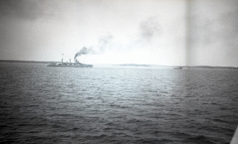 Vaade [laevatekilt] merel mööduvale aurulaevale, silmapiiril saared ja rannik