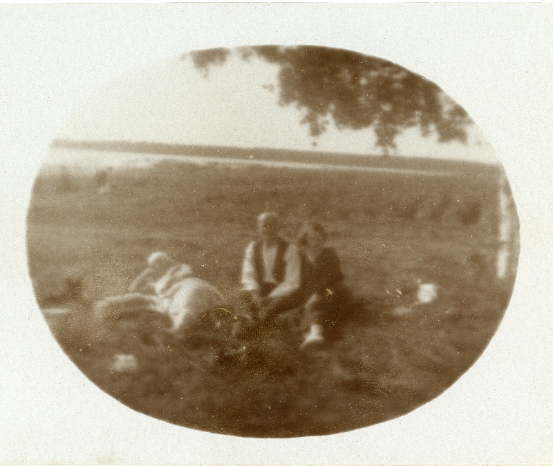 Kaks naist ja mees istumas õues.