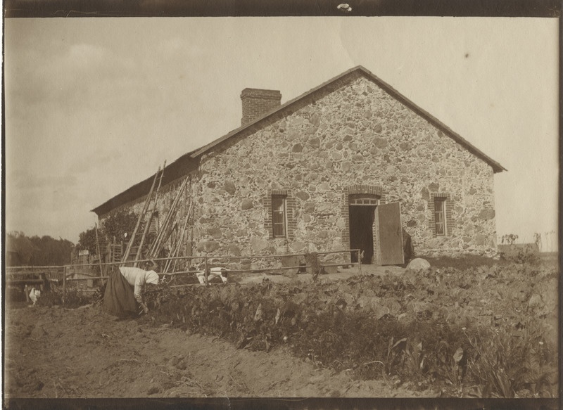 Mõisateenija peenral töötamas, esiplaanil ait