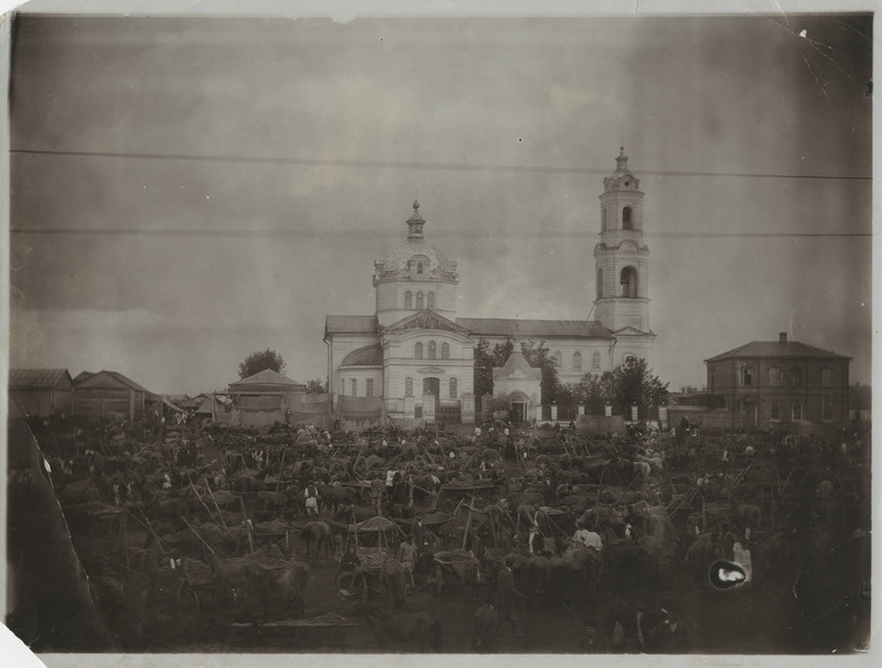 Suur hulk inimesi hobuste ja heinavankritega kiriku esisel alal
