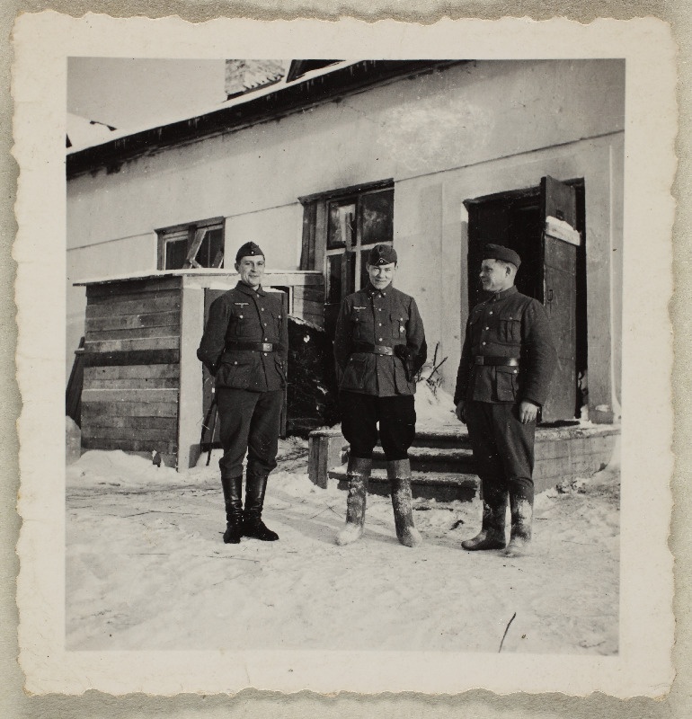 Kolm sõdurit maja ees talvisel ajal