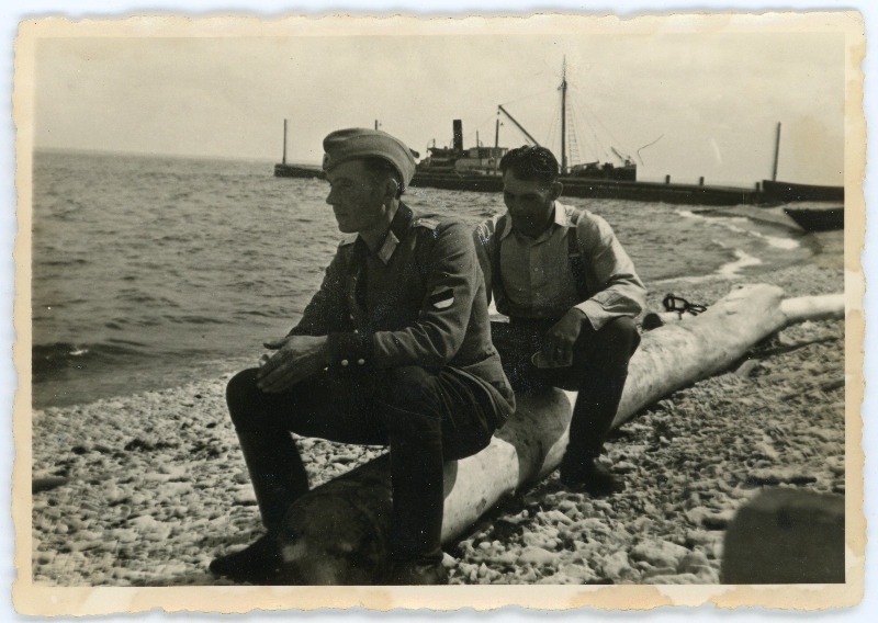 Kaks meest Pakri saare rannas palgil istumas, üks neist Eesti Leegioni mundris ja eraldusmärkidega