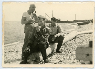 Eesti Leegioni sõdurid Pakri saare rannas palgil istumas, üks nendest mundris ja eraldusmärkidega  similar photo