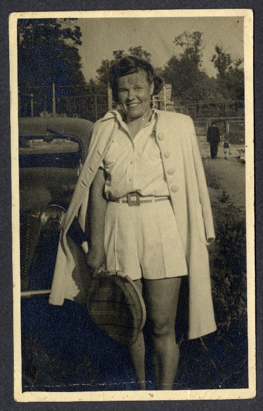 Tennisekostüümis naine reket käes (Ida Laas?), selja taga auto