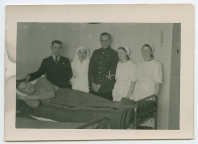 Grupp inimesi, nende hulgas haiglaõed, patsiendi [Arnold Reilsoni?] voodi juures  duplicate photo