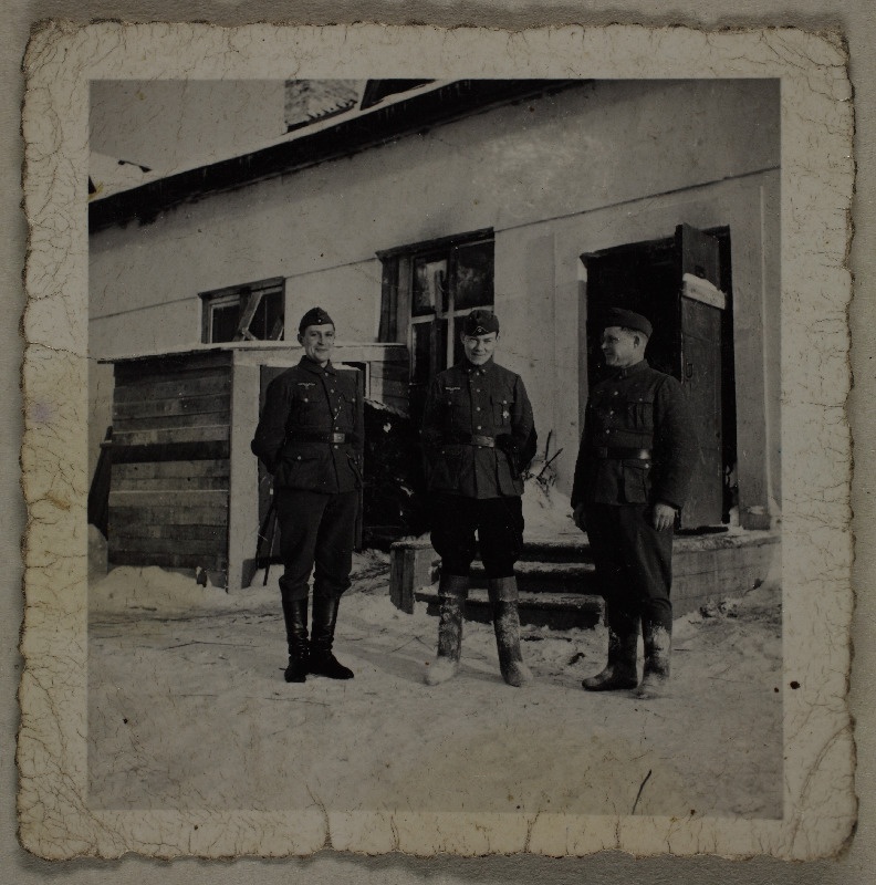 Kolm sõdurit talvisel ajal hoone taustal