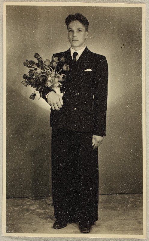 Fotoportree ülikonnas noormehest koos lillekimbuga