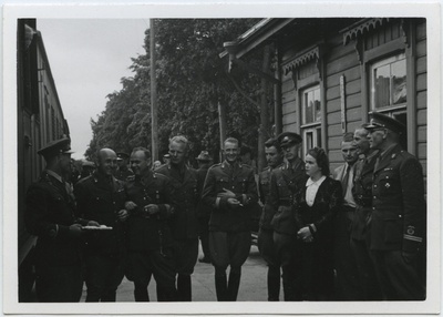 Grupp vormis mehi ja noor naine suvisel ajal raudteejaamas  duplicate photo
