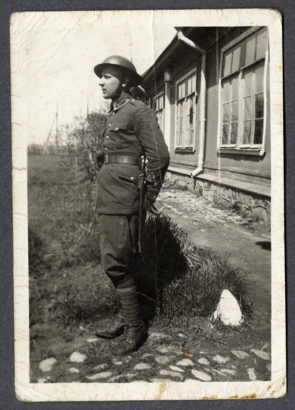 Sõdurimundris tundmatu noormees seisab maja ees