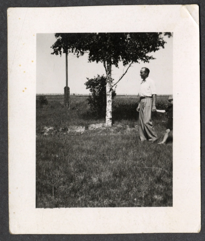 Osvald Asi väikese lapsega õues, taustal kask, elektripost ja aed