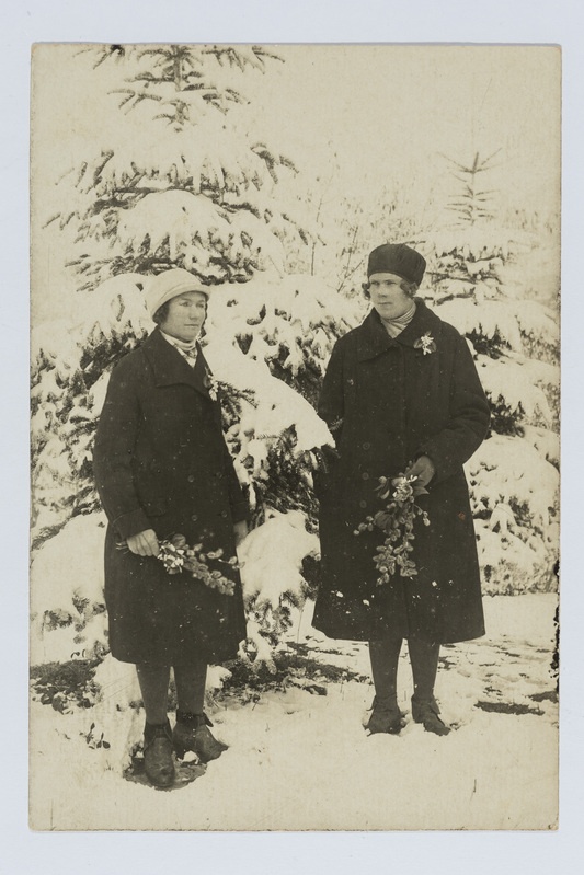 Kaks Kaukaasia naist pajuokstega lumiste kuuskede juures