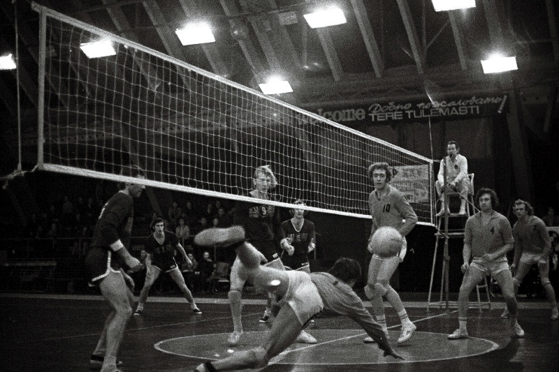 NSV Liidu võrkpallivõistlustel kohtuvad Tallinna "Kalevi" ja Vilniuse "Kuroaparatura" meeskond. Hüppel kalevlaste kapten Andres Karu, tagapool Peeter Talme, Kalle Kukk ja Arvo Priimägi.