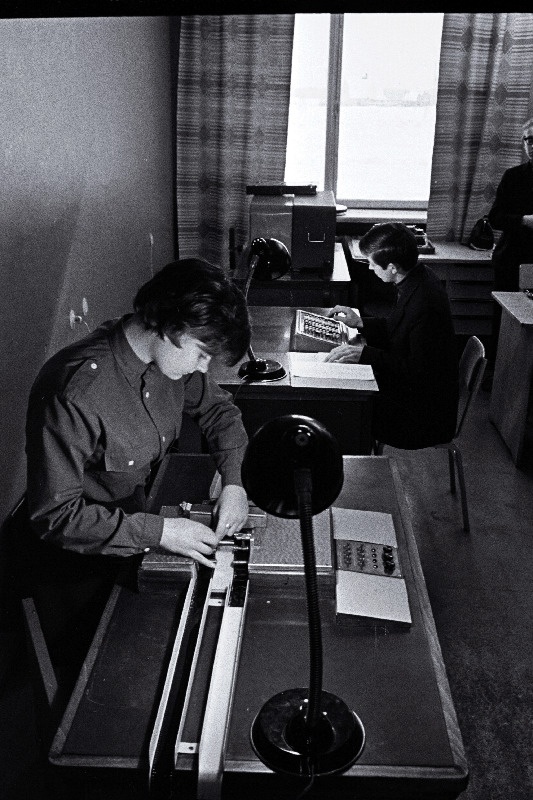 Nõo Keskkooli õpilased Õie Heinvee töötamas dubleerimislaual ja Peep Rosenberg perforeerimislaual.