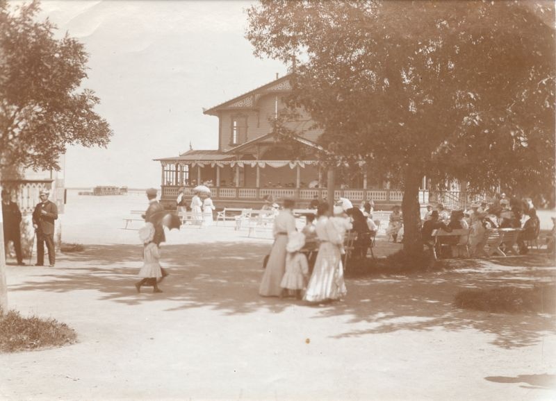 Foto. Suvituselu Suurel Promenaadil Haapsalus. Inimesed istumas valgetel pinkidel. u 1900.