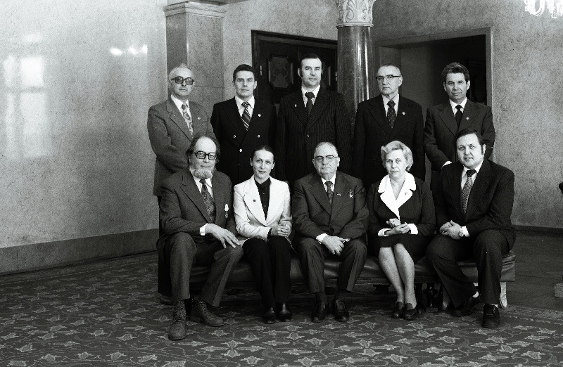 Eesti NSV Ülemnõukogu Presiidiumis autasustatud töötajad: NSV Liidu rahvakunstnik, RAT Estonia solist Hendrik Krumm (I reas paremalt 1.), Eesti NSV rahvakunstnik, RAT Estonia solist Mati-Johannes Palm, Eesti NSV teenelised tööstustöötajad tootmiskoondise Polümeer komplekteerija Aleksandra Galjastova, Tarbekeemia Tootmiskoondise Flora klaasimaalija Vilma Heinaste ja  Tartu Valu- ja Mehaanikakatsetehase direktor Heinrich Kaio, Eesti NSV teenelised energeetikud remondiettevõtte Eesti Energoremont lukksepp Volli Riitsaar, Eesti NSV Energeetika ja Elektrifitseerimise Tootmisvalitsuse peainseneri asetäitja Andrei Semjonov ja Balti Soojuselektrijaama turbiinijaoskonna vanemmasinist  jätkub: Jüri Šigarev, Eesti NSV rahvakunstnik, skulptor Matti Varik, Eesti NSV teeneline kunstnik, skulptor Jaak Soans, Eesti NSV teeneline kultuuritegelane, maalikunstnik Konstantin Mihailov, Eesti NSV teeneline tööstustöötaja Jaan Tepandi, Rakvere rajooni Õitsengu kolhoosi lüpsja Elle Liivak,