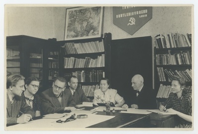 TRÜ eesti keele ja soome-ugri keelte kateedri koosolek 7. VII 1952. a. Vasakult: aspirant Eduard Vääri, vanemlaborant Niina Raid, prof. Paul Ariste, dots. Arnold Kask, vanemõpetaja Gerda Laugaste, prof. Johannes Voldemar Veski ja vanemlaborant Salme Nigol. Suurus 17,3x11,5 cm.  similar photo