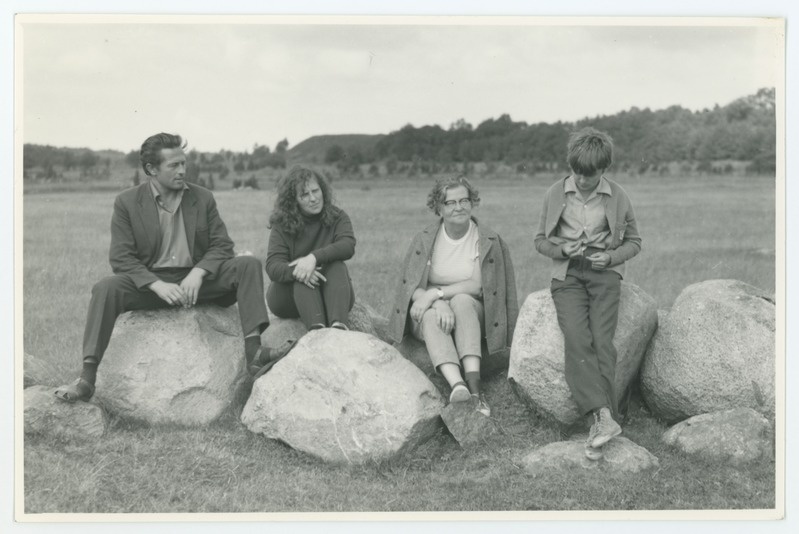 Läänemaal murdekogumise ekspeditsioonil 14. VIII 1973. a. Linnamäe lähedal istuvad suurtel kividel Maara Veinberga (vasakult teine), Niina Raid (kolmas). Foto suurus 14,6x9,6 cm.