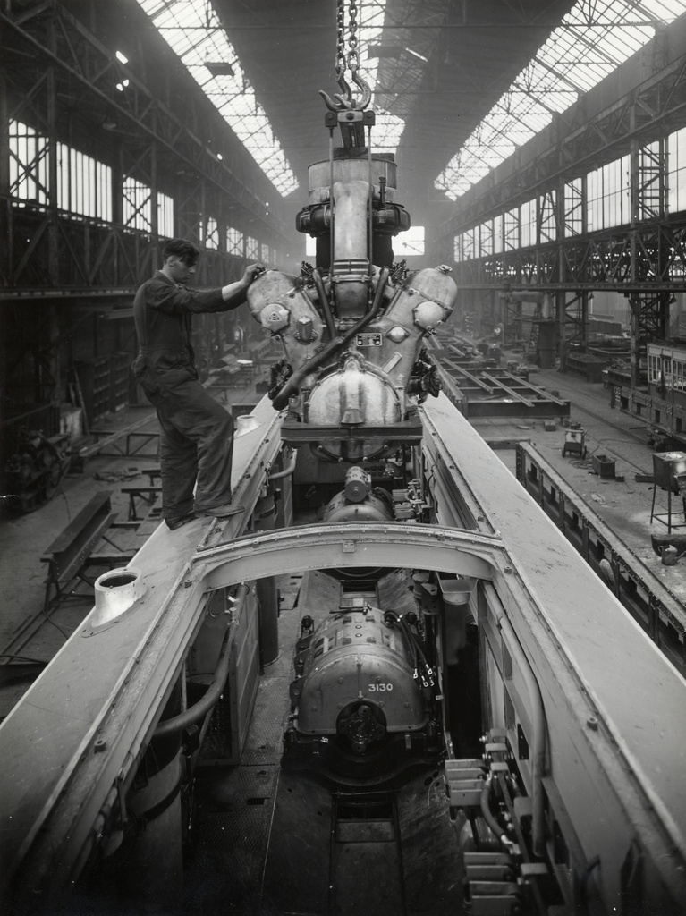 Afbeelding van een in aanbouw zijnd mD-rijtuig van een diesel-electrisch treinstel DE 5 (serie 51-68) van de N.S. bij Werkspoor te Zuilen, tijdens de plaatsing van één van de Maybach-motoren.