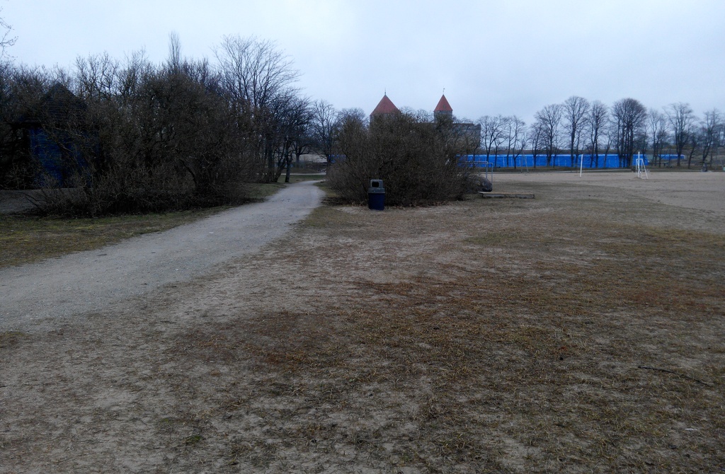 Kuressaare rand, suvitajad murul istumas, taamal rannakohvik ja linnuse tornid rephoto