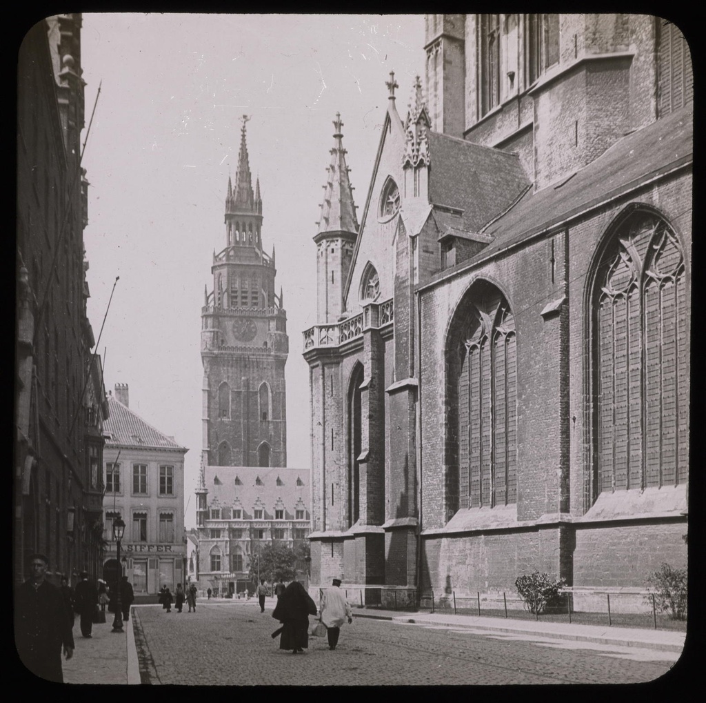 Gand, St Bavon et le Beffroi Mazo, E. - Ghent (Belgium). Part of the Gothic cathedral, street travelled by several pedestrians, and town hall and tower in the background.